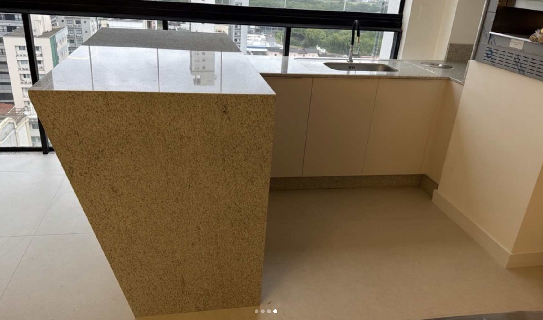 Ilha de cozinha em granito com vista para a cidade - projeto Cia do Mármore